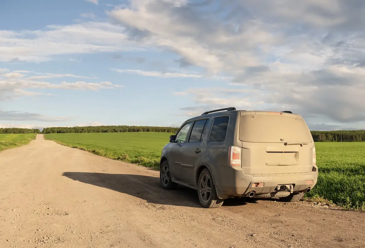 SUV-Mietwagen auf einer unbefestigten Schotterstraße durch die Prärie – die Nutzung solcher Straßen kann laut Rental Agreement eingeschränkt sein