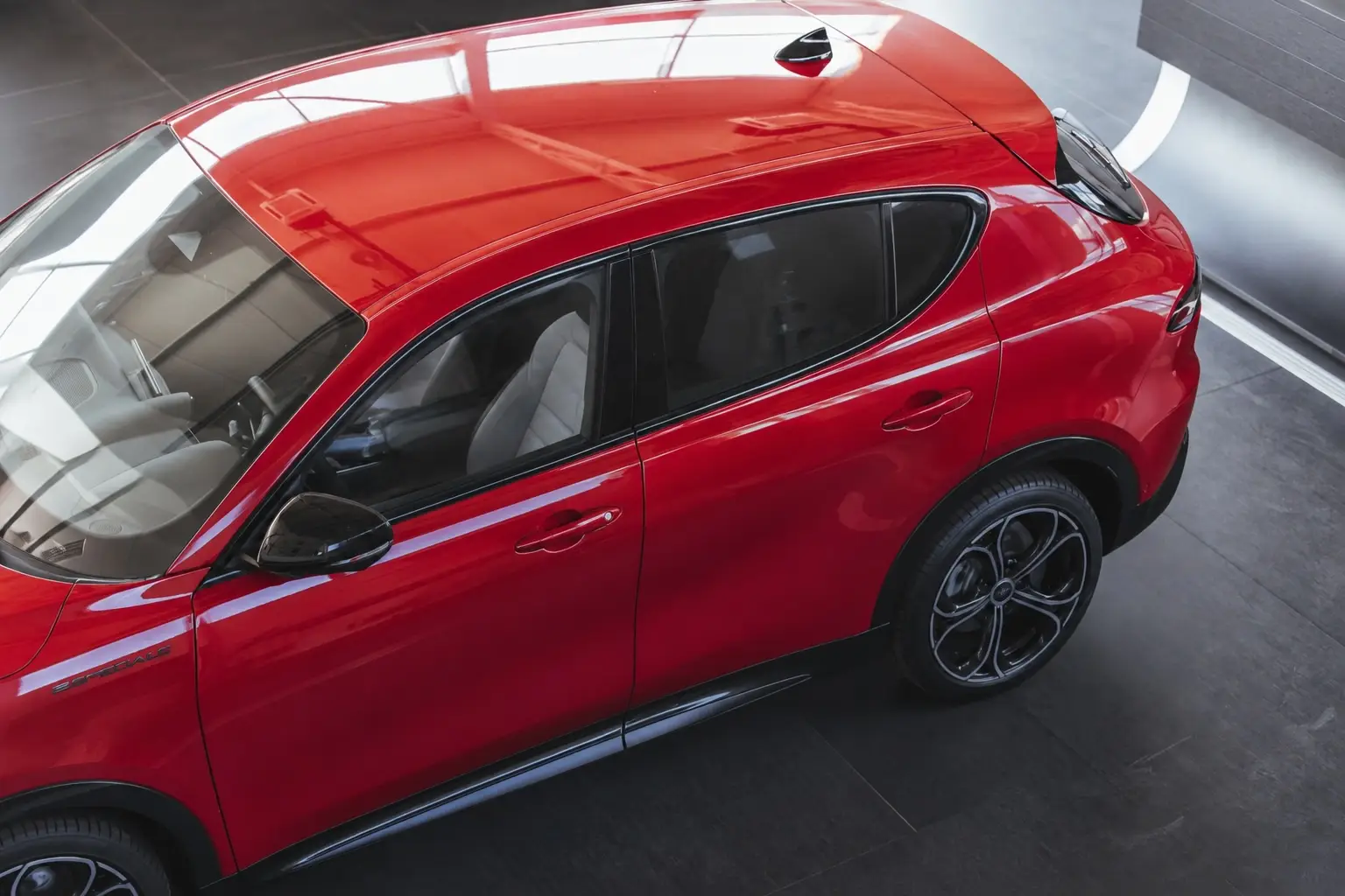 Roter SUV als Mietwagen in einem Autohaus-Showroom aus der Vogelperspektive