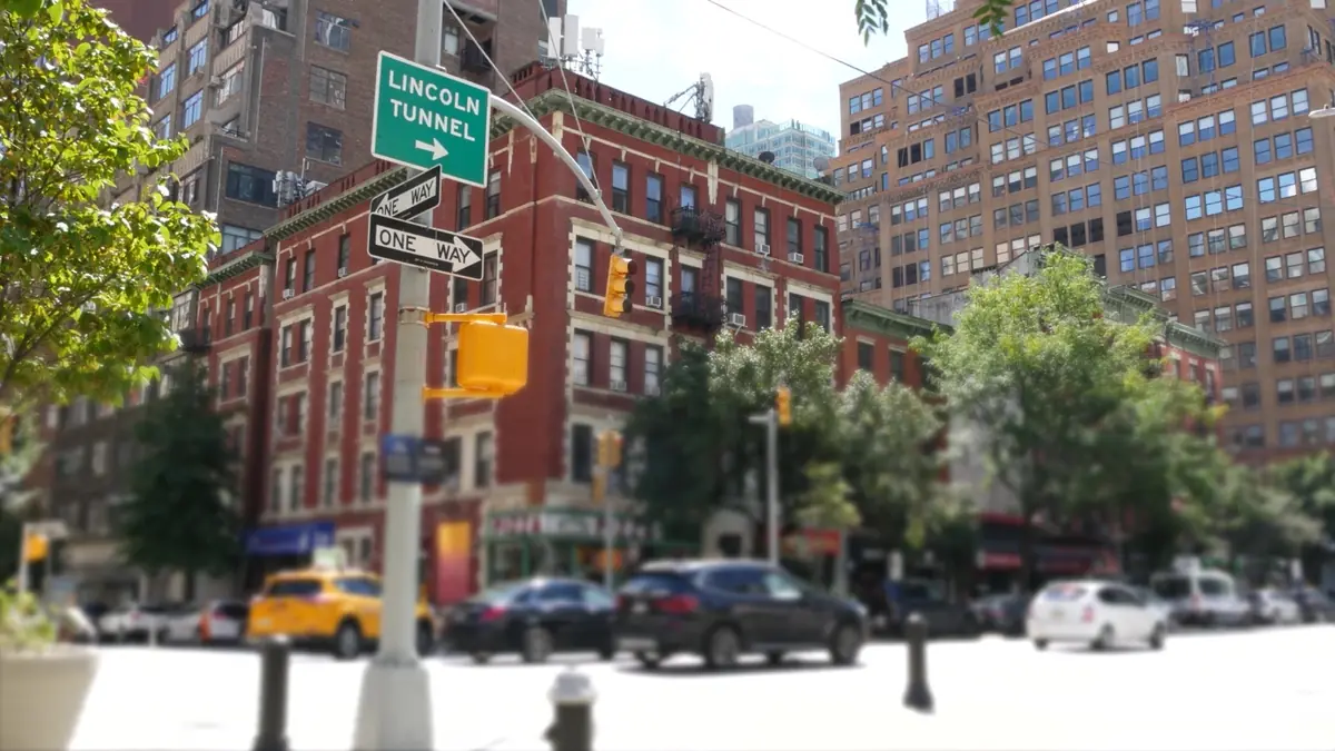 Städtische Kreuzung in New York mit Einbahnstraßenschildern und Wegweiser zum Lincoln Tunnel als Sinnbild für Stadtstation und Einwegmiete