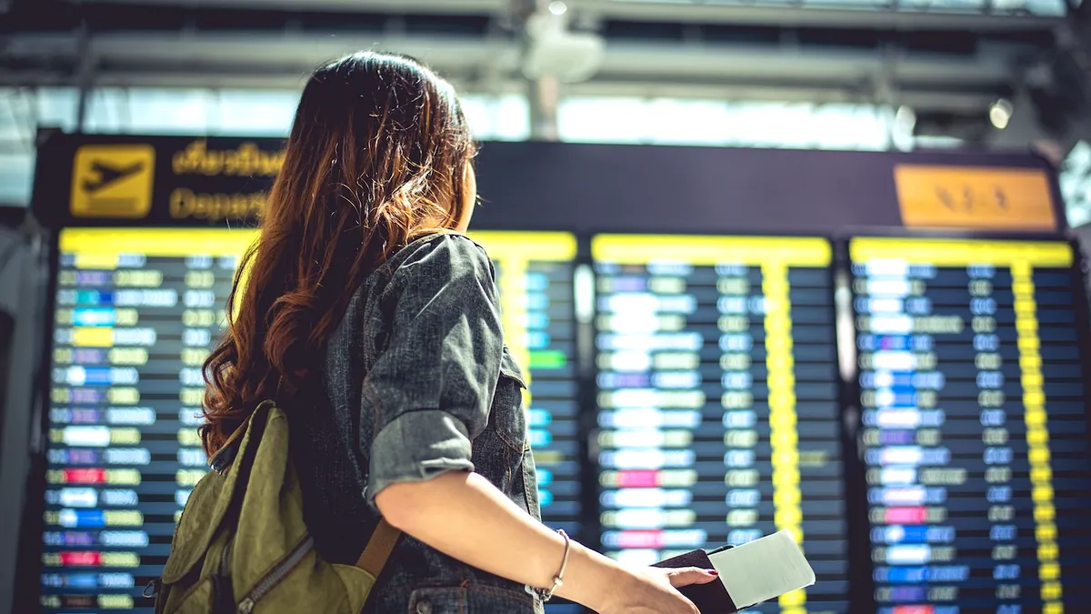 Abflugtafel am Flughafen als Symbol für Flugnummer und verspätete Mietwagenabholung