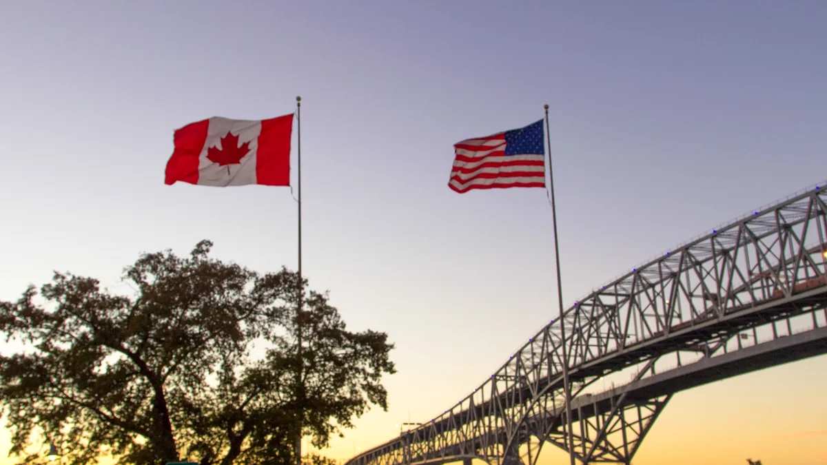 Grenzübergang zwischen den USA und Kanada mit amerikanischer und kanadischer Flagge
