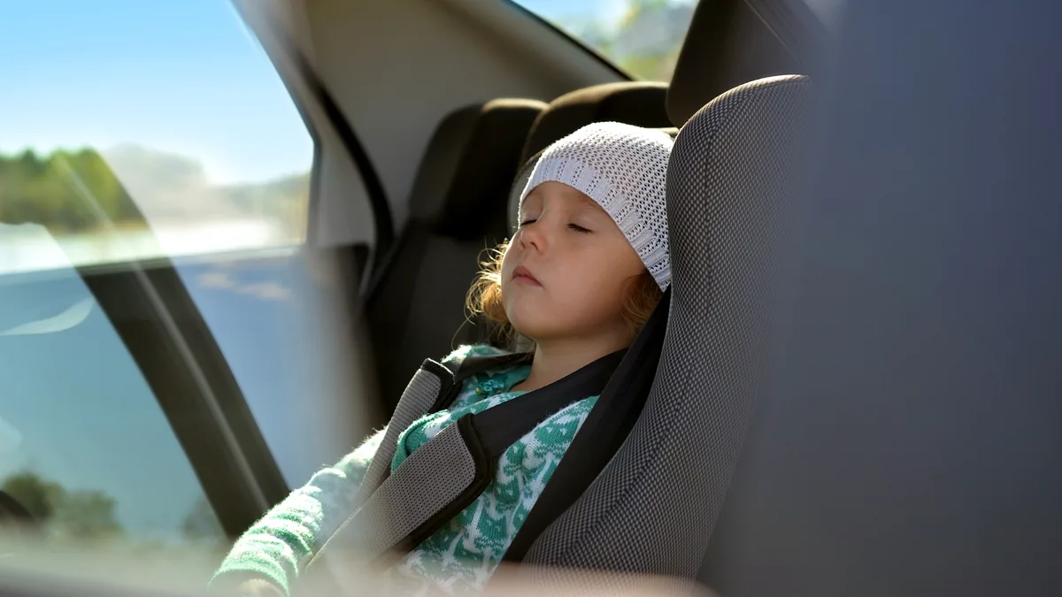 Schlafendes Kind in einem Kindersitz während einer Autofahrt in den USA